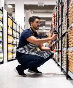 Grocery store employee scanning inventory with help from Rapid Grocery POS solutions to increase sales in retail grocery store.